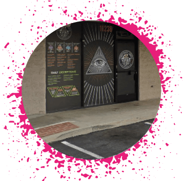 Neon green sign that is lit up that says 'Cookie Plug' that's on a tan building with large cookie decals on the window.