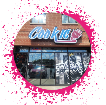 Brick storefront with a large black and white graffiti mural with Biggie, sitting on speakers with cookies all around him.